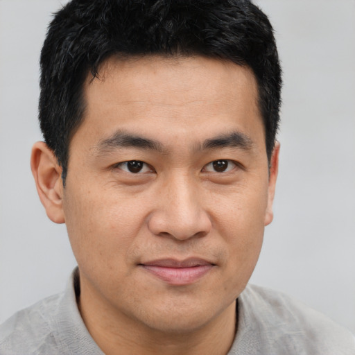 Joyful asian young-adult male with short  brown hair and brown eyes