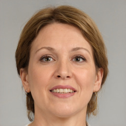 Joyful white adult female with medium  brown hair and grey eyes