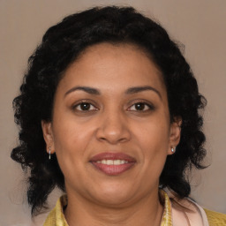 Joyful latino adult female with medium  brown hair and brown eyes