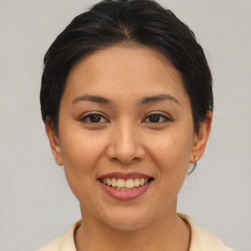 Joyful asian young-adult female with short  brown hair and brown eyes