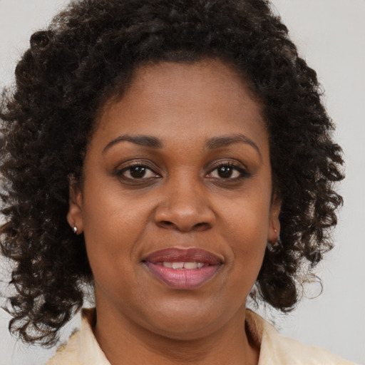 Joyful black adult female with medium  brown hair and brown eyes
