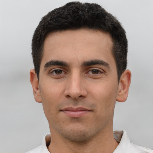 Joyful white young-adult male with short  black hair and brown eyes