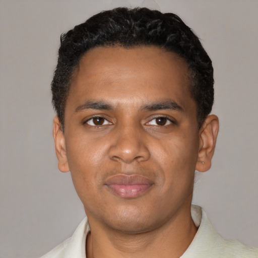 Joyful black young-adult male with short  black hair and brown eyes