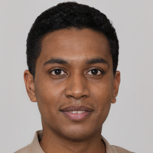Joyful black young-adult male with short  black hair and brown eyes