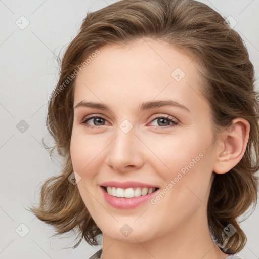 Joyful white young-adult female with medium  brown hair and blue eyes