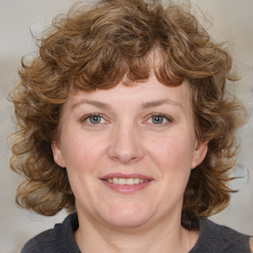 Joyful white adult female with medium  brown hair and blue eyes