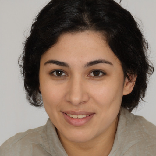 Joyful latino young-adult female with medium  brown hair and brown eyes