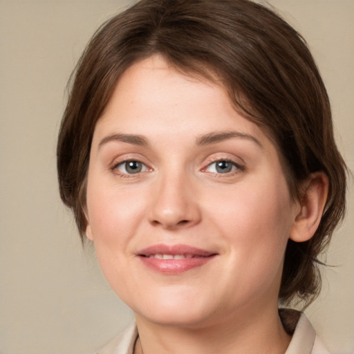 Joyful white young-adult female with medium  brown hair and green eyes