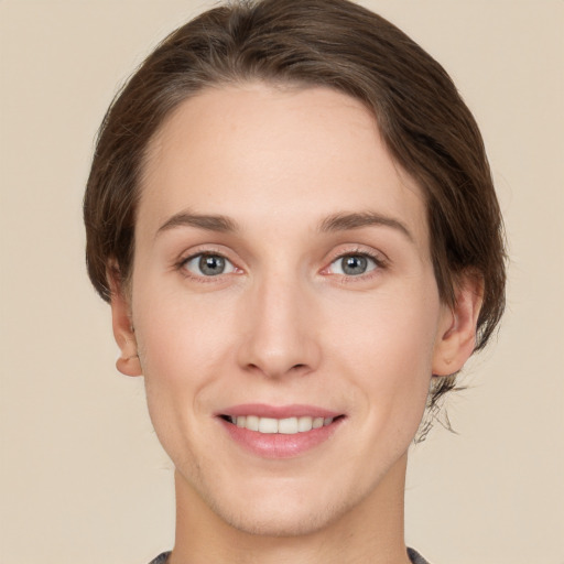 Joyful white young-adult female with short  brown hair and green eyes