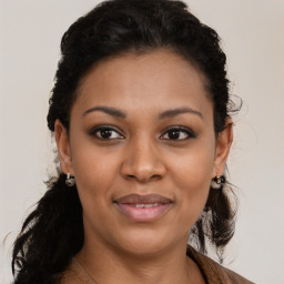 Joyful black young-adult female with long  brown hair and brown eyes
