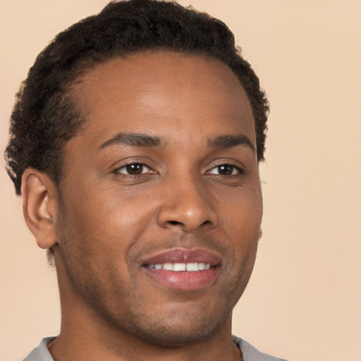 Joyful black young-adult male with short  brown hair and brown eyes