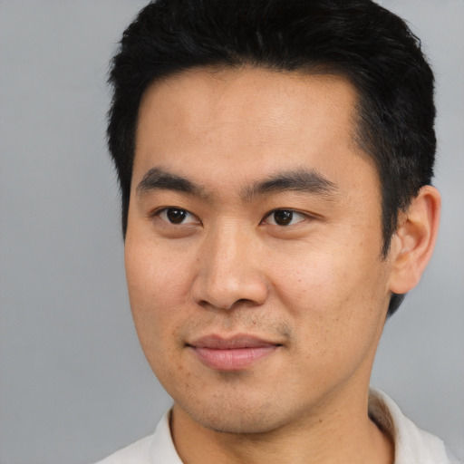 Joyful asian young-adult male with short  black hair and brown eyes