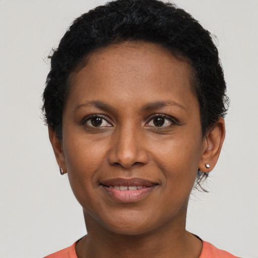 Joyful black young-adult female with short  black hair and brown eyes