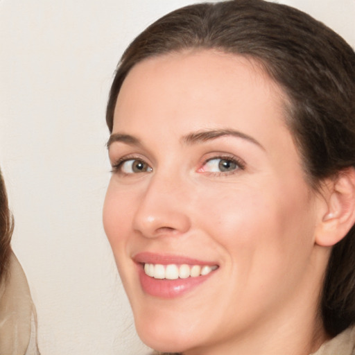 Joyful white young-adult female with medium  brown hair and blue eyes