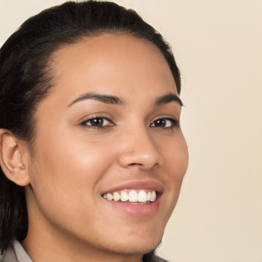 Joyful latino young-adult female with long  brown hair and brown eyes