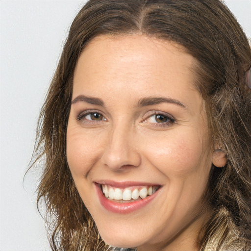 Joyful white adult female with long  brown hair and brown eyes