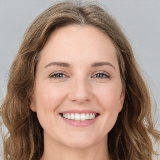 Joyful white young-adult female with long  brown hair and grey eyes