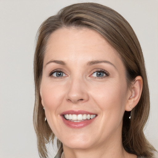 Joyful white adult female with medium  brown hair and grey eyes