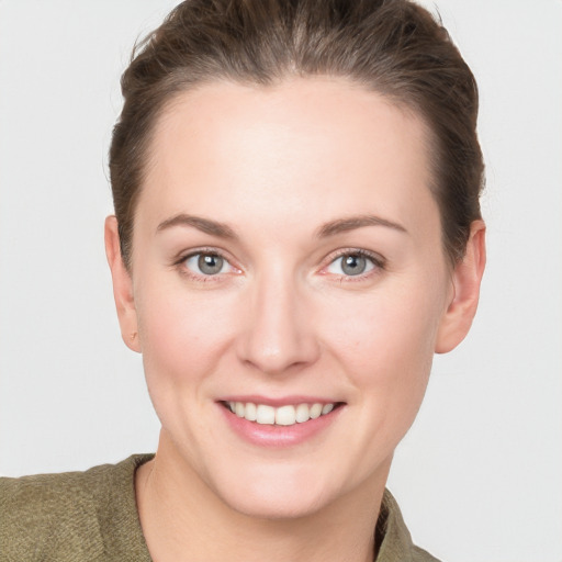 Joyful white young-adult female with short  brown hair and grey eyes