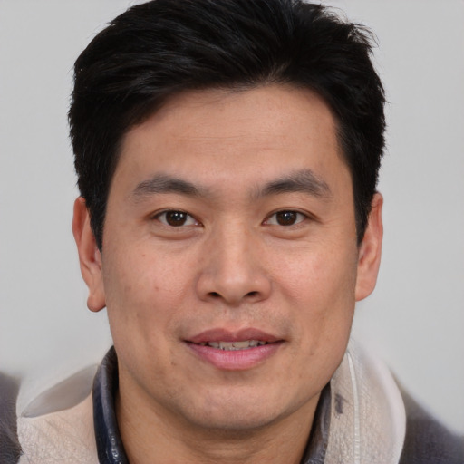 Joyful asian adult male with short  brown hair and brown eyes