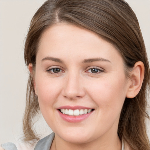 Joyful white young-adult female with long  brown hair and grey eyes