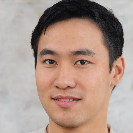 Joyful asian young-adult male with short  black hair and brown eyes