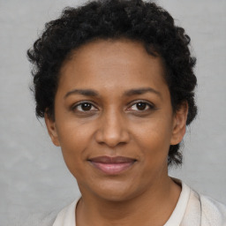 Joyful black adult female with short  brown hair and brown eyes