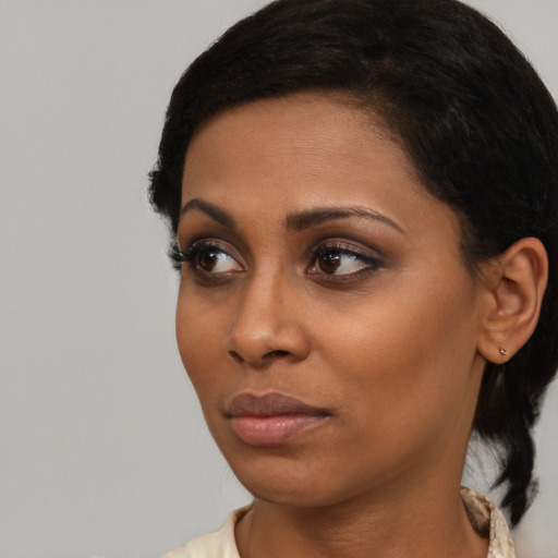 Joyful black young-adult female with medium  black hair and brown eyes