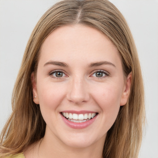 Joyful white young-adult female with long  brown hair and green eyes