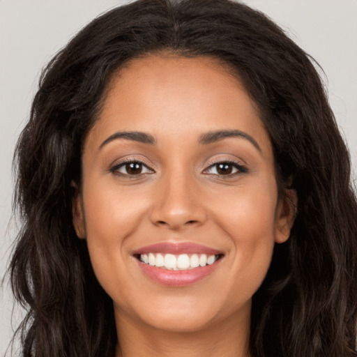 Joyful latino young-adult female with long  brown hair and brown eyes