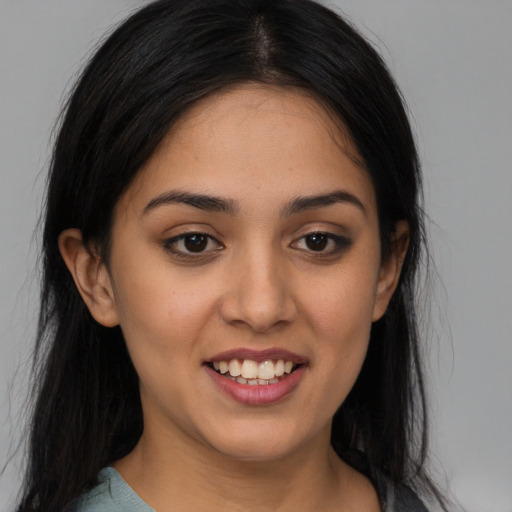 Joyful latino young-adult female with long  black hair and brown eyes