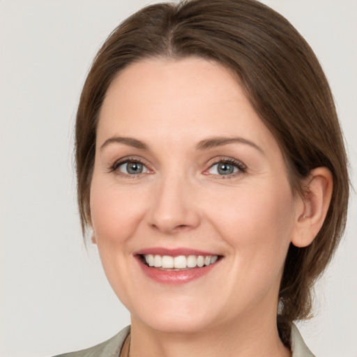 Joyful white young-adult female with medium  brown hair and green eyes