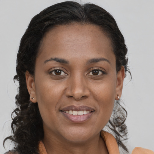 Joyful black young-adult female with long  brown hair and brown eyes