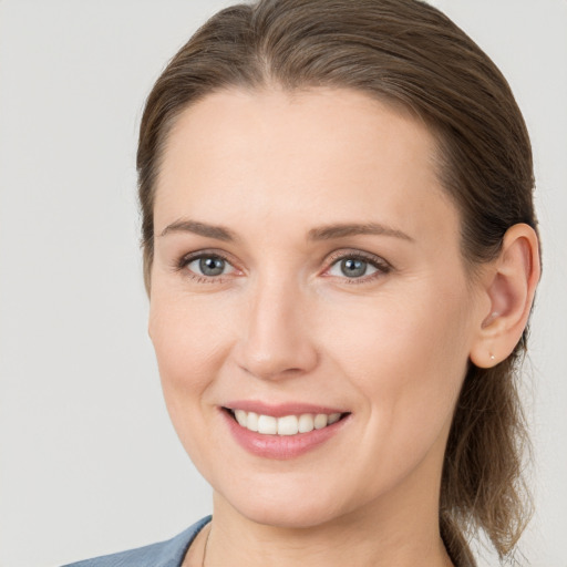 Joyful white young-adult female with medium  brown hair and grey eyes