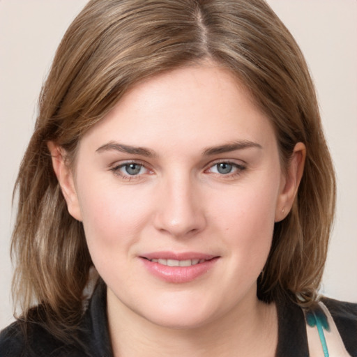 Joyful white young-adult female with medium  brown hair and blue eyes