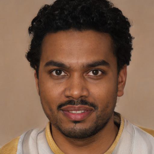 Joyful black young-adult male with short  brown hair and brown eyes
