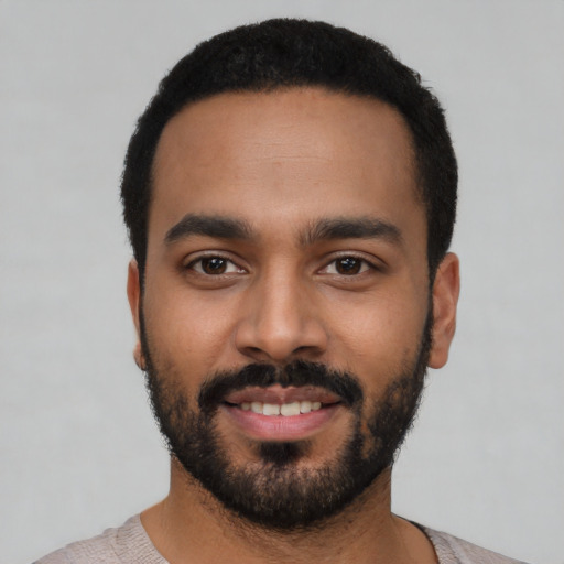 Joyful latino young-adult male with short  black hair and brown eyes