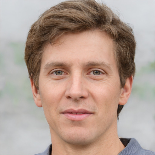 Joyful white adult male with short  brown hair and grey eyes