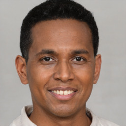 Joyful latino adult male with short  black hair and brown eyes