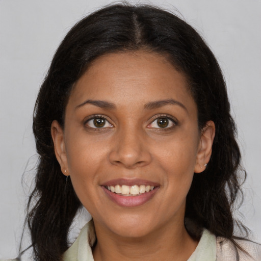 Joyful black adult female with medium  brown hair and brown eyes