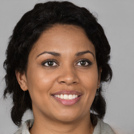 Joyful black young-adult female with medium  brown hair and brown eyes