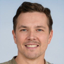 Joyful white adult male with short  brown hair and grey eyes