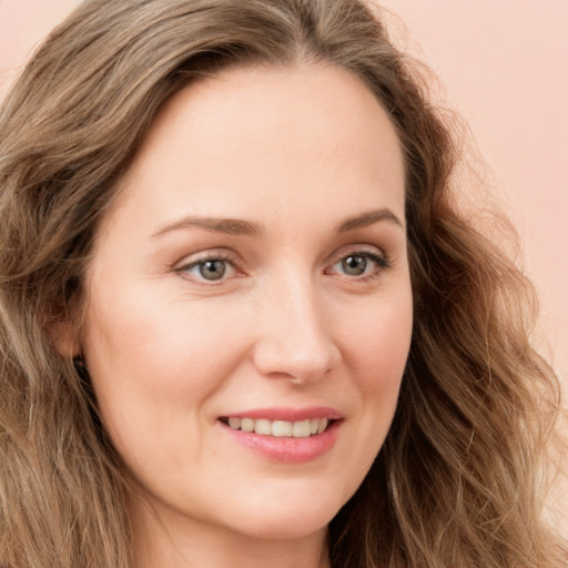 Joyful white young-adult female with long  brown hair and green eyes