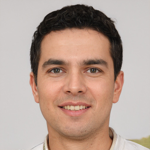 Joyful white young-adult male with short  black hair and brown eyes