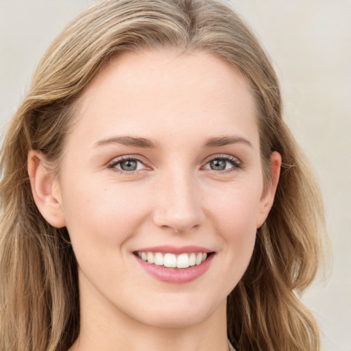 Joyful white young-adult female with long  brown hair and blue eyes