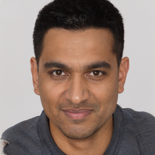 Joyful latino young-adult male with short  black hair and brown eyes
