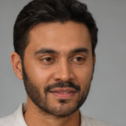 Joyful latino young-adult male with short  brown hair and brown eyes