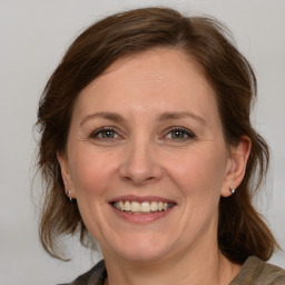 Joyful white adult female with medium  brown hair and grey eyes