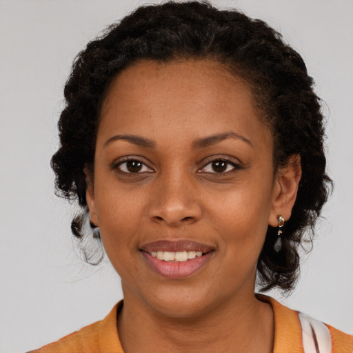 Joyful black young-adult female with medium  brown hair and brown eyes