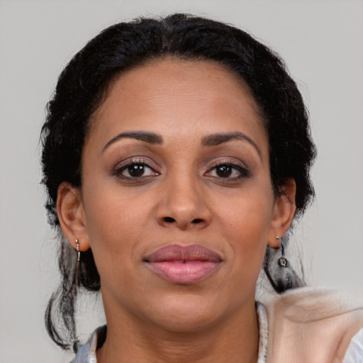 Joyful latino adult female with medium  brown hair and brown eyes